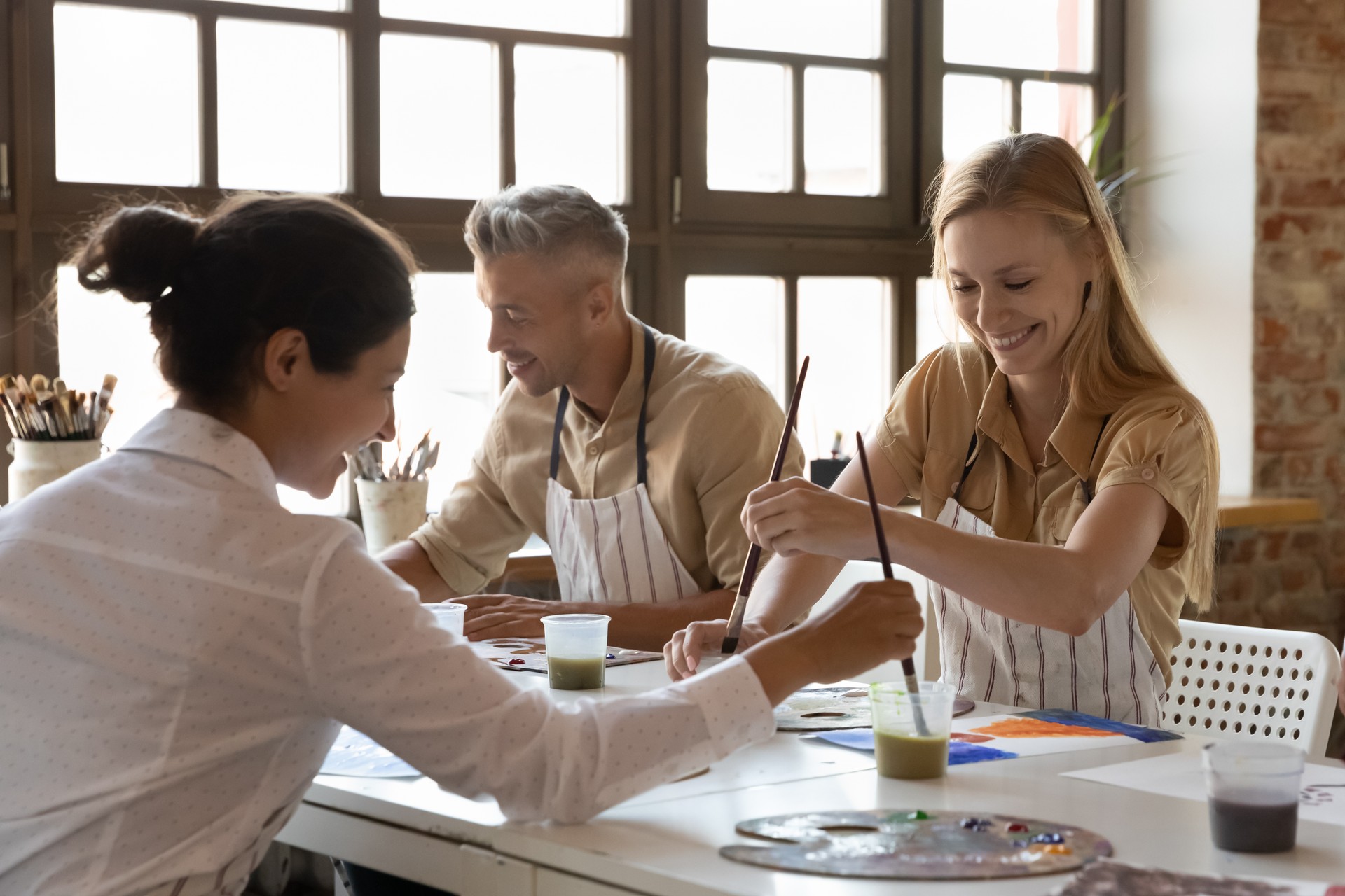 Cheerful diverse art school classmates girls talking on class